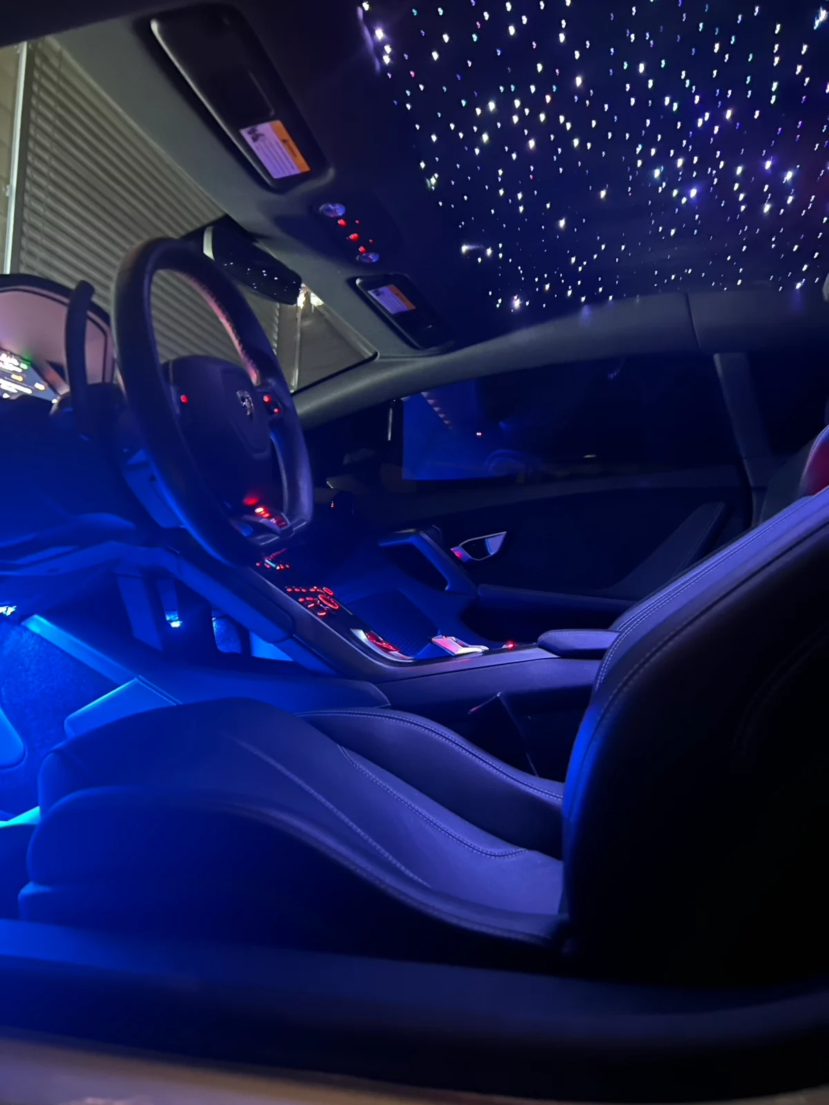 Blue-lit Lamborghini Huracán cabin with a custom suede starlight headliner