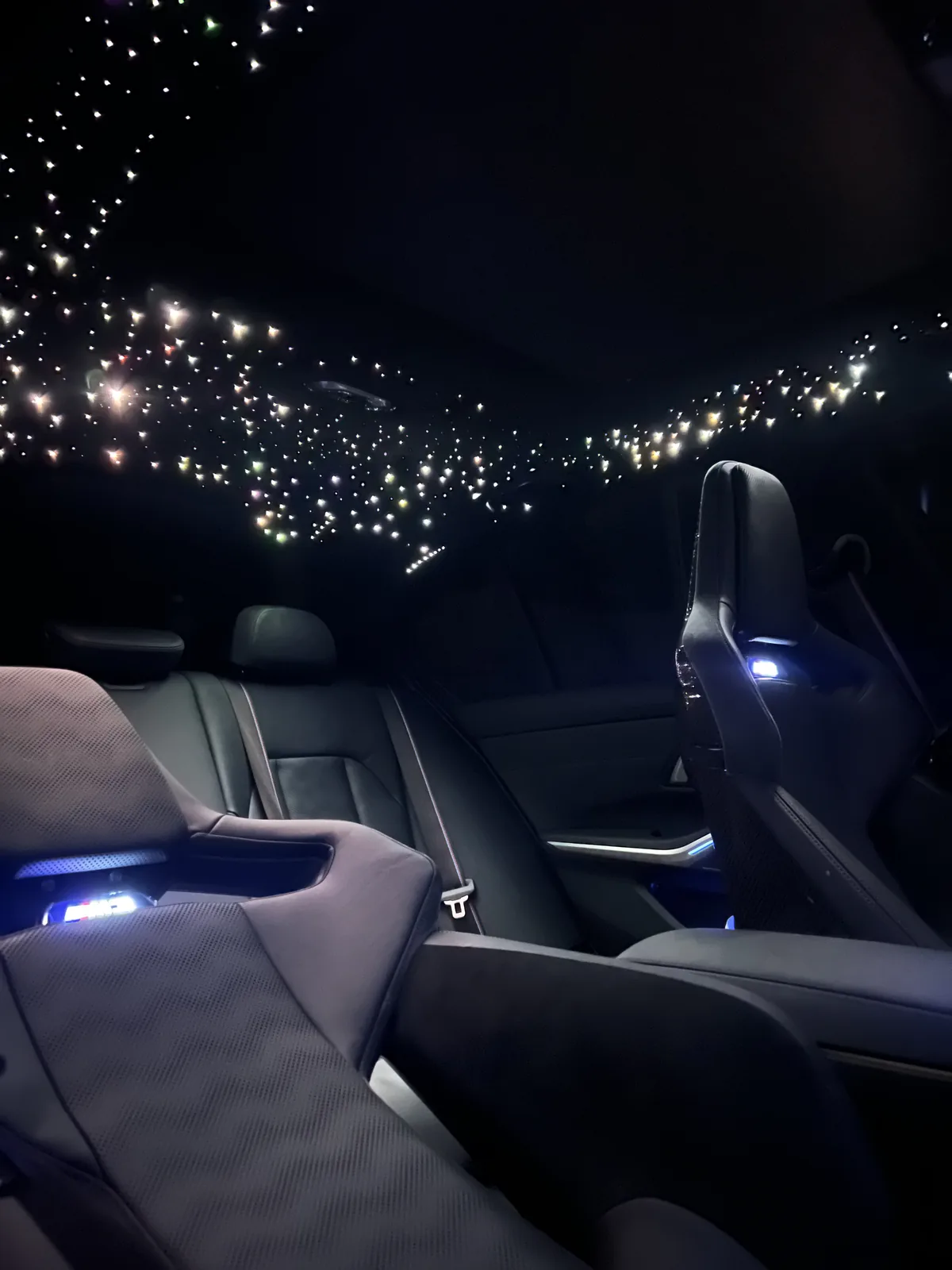 BMW M3 carbon bucket seats with blue ambient light and a starlight headliner