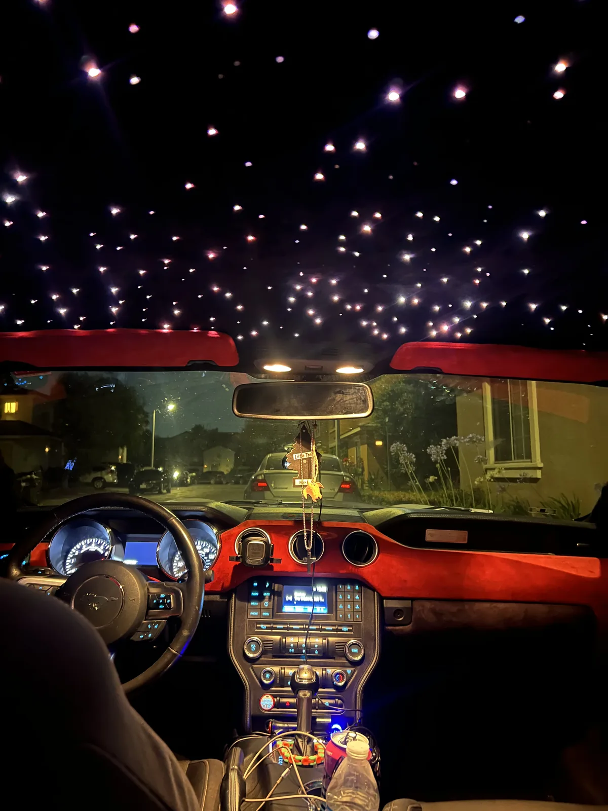 Ford Mustang cockpit with a starlight headliner and red dash lighting at night